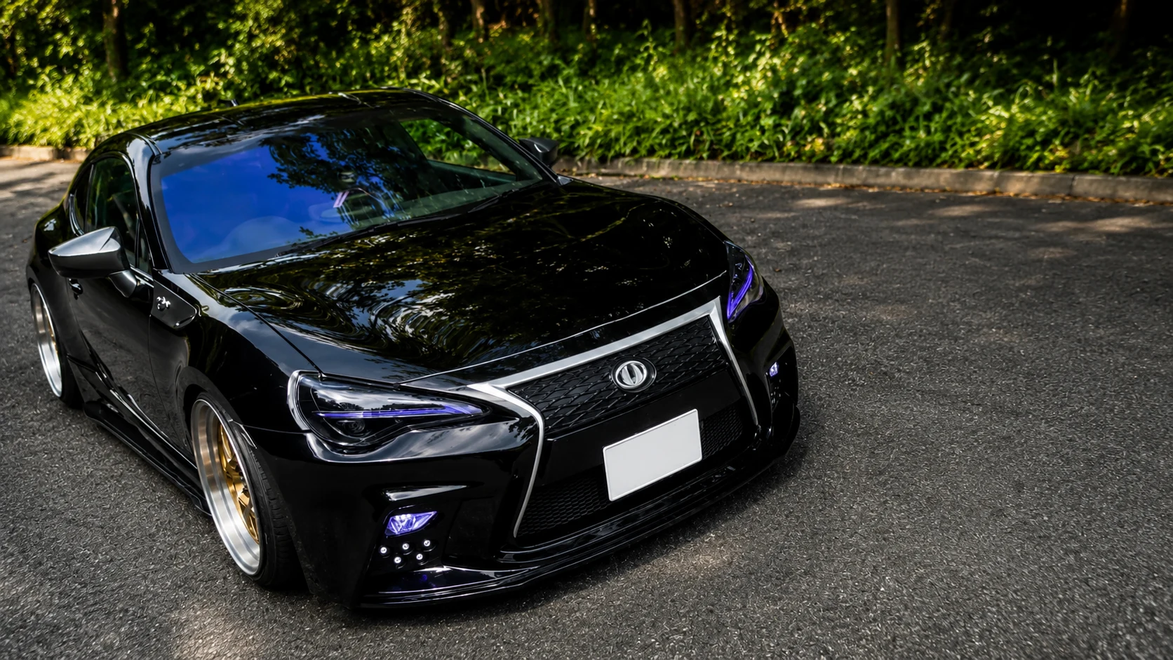 木々に囲まれた路面に停車する黒いGT86